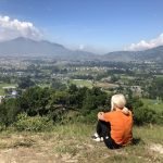 Jayne sitting on top of a hill on her Nepal Trip