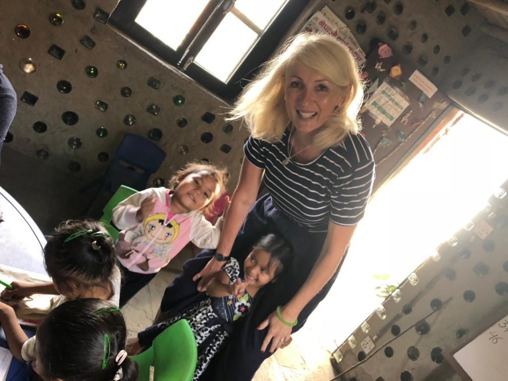 Jayne smiling with young children on her volunteering programme abroad