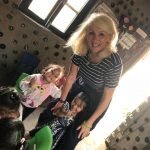 Jayne smiling with young children on her volunteering programme abroad