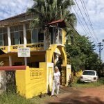 Jayne standing outside old aged home on one of her projects for volunteers