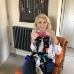 Jayne sitting on chair smiling with lockdown hair