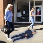 Jayne walking along street with George Clooney height cutout on ground