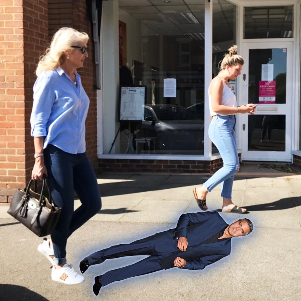 Jayne walking along street with George Clooney height cutout on ground