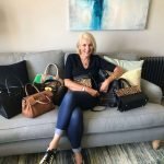 Jayne with handbags on sofa writing blogs on women