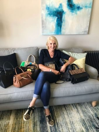 Jayne with handbags on sofa writing blogs on women